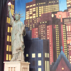 A Statue of Liberty in front of a city backdrop.