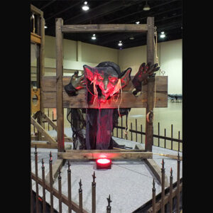 A statue of Stocks and Shackles with a red light on it.