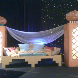 A stage with a Sultan's Couch and a curtain over it.