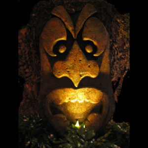 An image of an African Tiki Gods statue lit up in the dark, representing the majestic presence of African Tiki Gods.