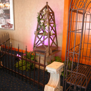 A Tuilerie Gardens bench in front of a wrought iron fence.