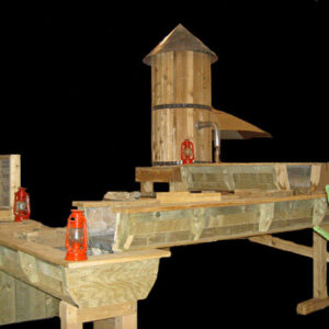 A wooden structure with a Water Pump on it.