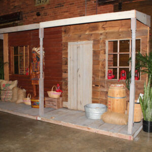 A Western Cigar Storefront building with a porch and potted plants.