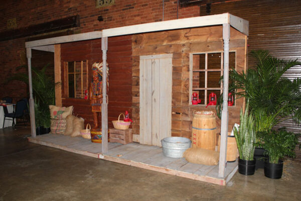 A Western Cigar Storefront building with a porch and potted plants.