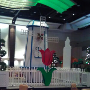 A windmill in the middle of a room with tables and chairs.