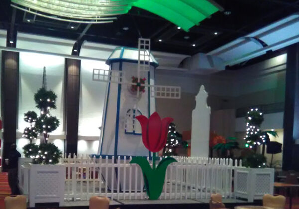 A windmill in the middle of a room with tables and chairs.