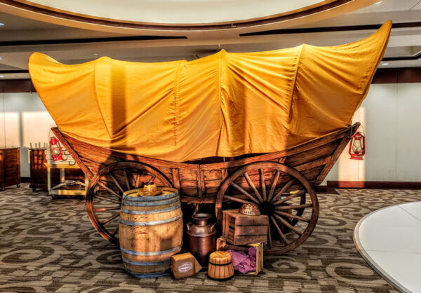 A Chuck Wagon in a room with barrels and barrels.