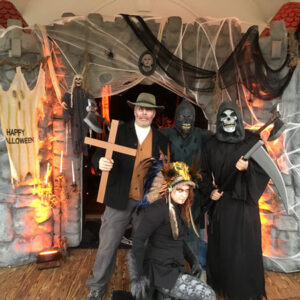 A group of people posing in front of a Caskets.