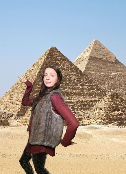 A woman taking a selfie in front of the pyramids using a Mirror Me Photo Booth