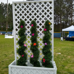 A white lattice panel planter with flowers on it.