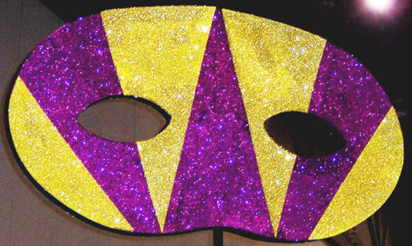 A purple and yellow Mardi Gras Theme Decor on a stand.