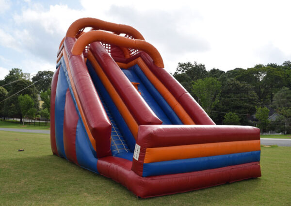 A giant water slide bounce house in a grassy area.