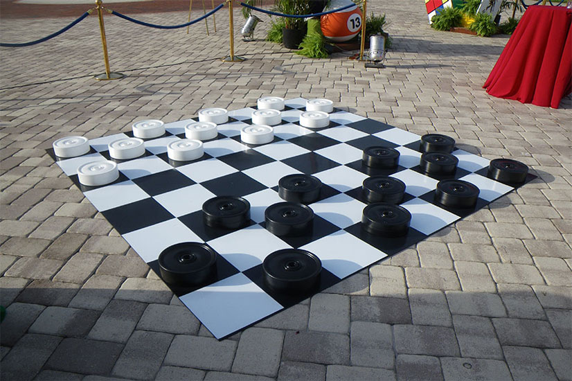 An outdoor chess board on a brick walkway.