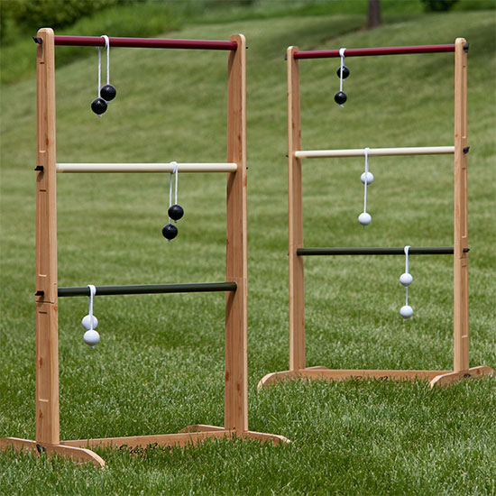 Two wooden ladders set up as a lawn game on a grassy field.