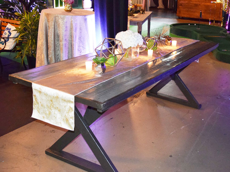 An event table rental with candles and flowers on it.