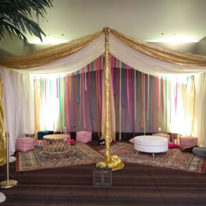 An Arabian Tent with a palm tree in the middle.