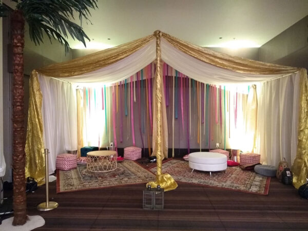 An Arabian Tent with a palm tree in the middle.