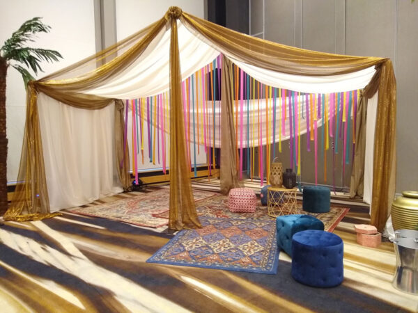 An Arabian Tent with a palm tree in the middle.