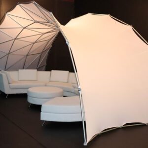 A Portable Event Space Arch with a white couch inside of it.