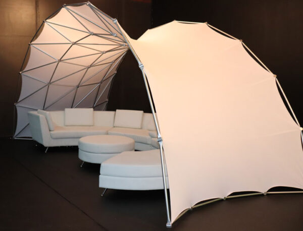 A Portable Event Space Arch with a white couch inside of it.