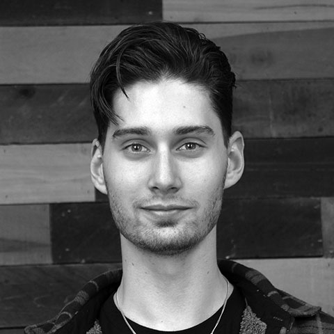 A black and white photo of a man in front of a wooden wall available for event rentals in Atlanta.