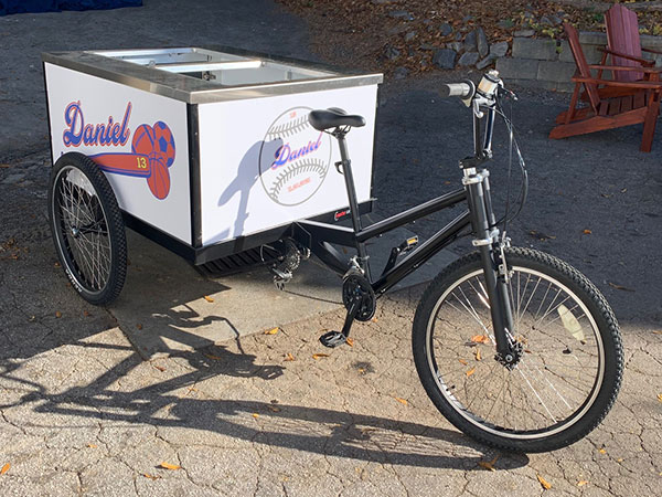 A special events bicycle with an ice cream cart on it.