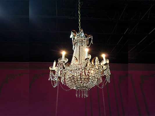 A stunning chandelier enhances the elegance of a room, perfect for corporate event decor or as an exquisite centerpiece in an event table design at an event center.