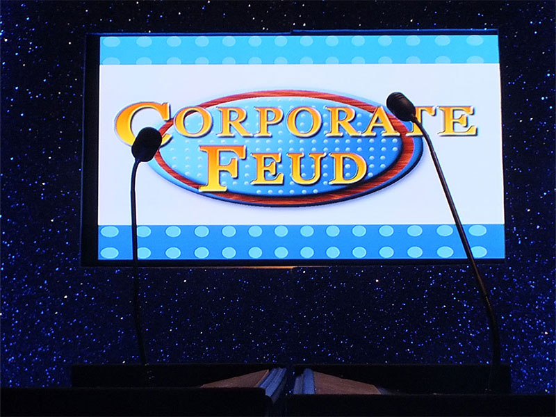 A corporate event stage with a sign that says "Corporate Feud" for effective event branding and marketing.