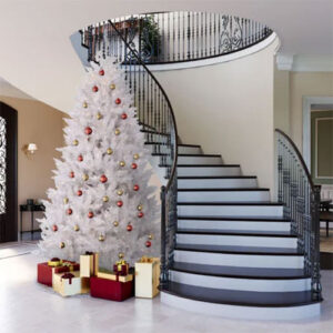 A white Christmas Trees in front of a staircase.