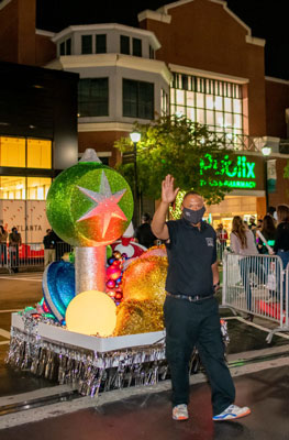 A man waving in front of a christmas float.