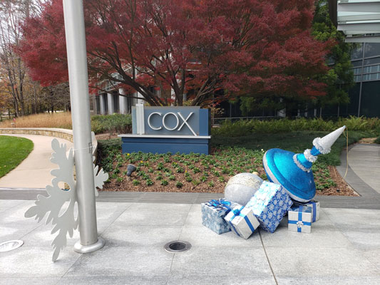 A christmas tree in front of the cox building.