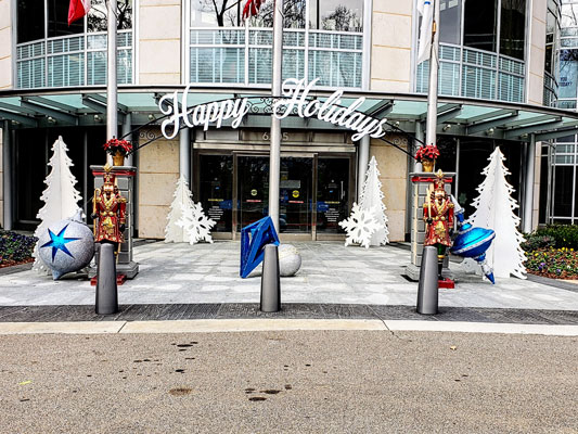 A building with festive Corporate Event Decor, including a sign that says happy holidays.