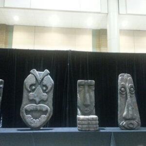 Four Tiki Gods are on display at a convention.