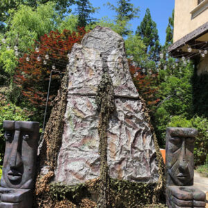 A statue of a Volcano in front of a house.