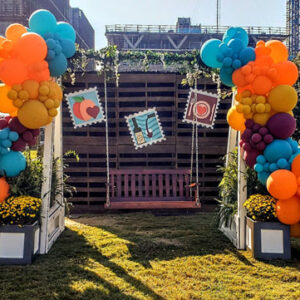 A balloon arch with colorful balloons and a Garden Swing Photo Op.