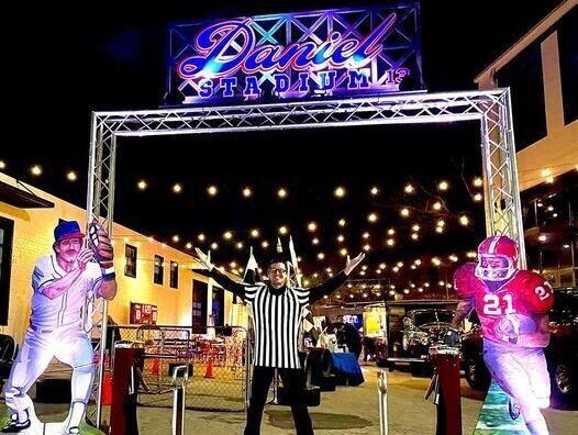 A man is standing in front of a lit up sign.
