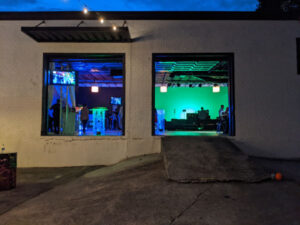 The entrance to a building at night with photography lighting illuminating the green screen cyc wall available for studio rental.