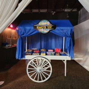 A white Candy Cart with a blue curtain in front of it.