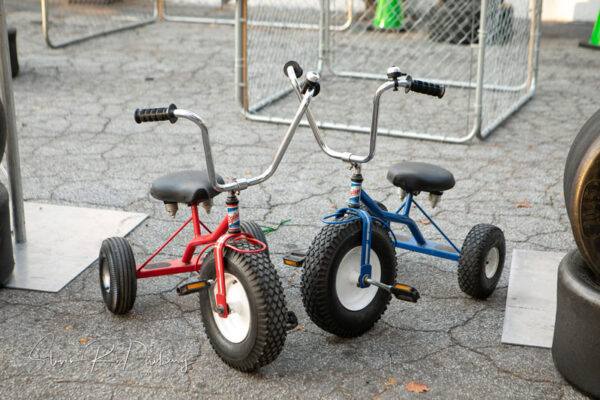 A blue tricycles and a red tricycles.