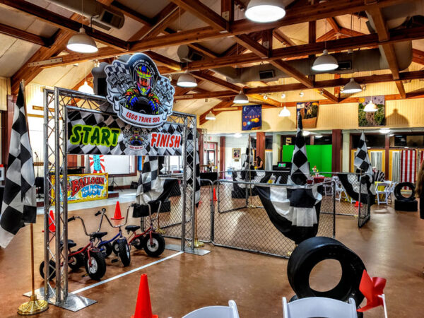 A party room decorated for a race car themed party featuring Tricycles for added excitement.