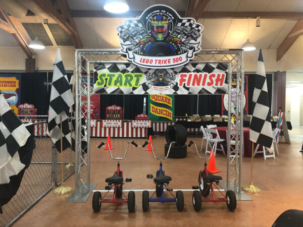 An interactive booth featuring two vibrant Tricycles and a striking checkered flag.