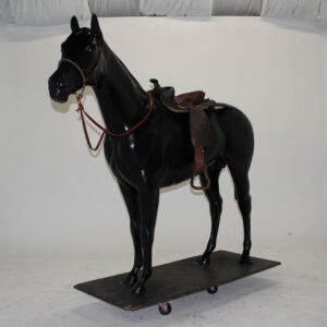 A black horse statue standing on a wooden platform.