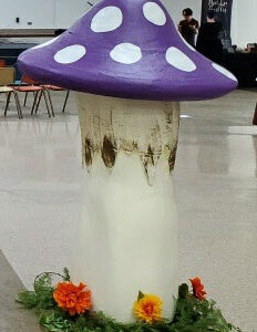 A purple and white Giant Mushroom in the middle of an airport.