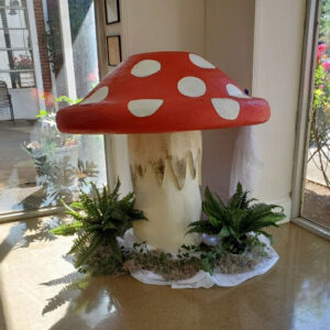 A red and white Giant Mushroom sitting on a table in a room.