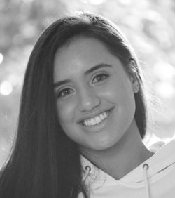 About Us: A black and white photo capturing the radiant smile of a woman.