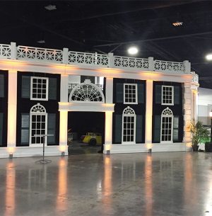 A white house transformed into a captivating theme party decoration inside a convention hall.